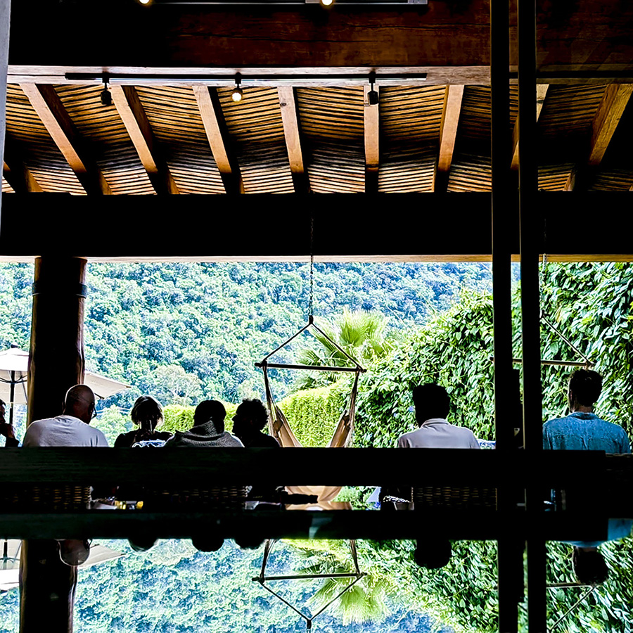 Eleusinia, Valle De Bravo, Mexico, group of retreat visitors sitting under a covered patio with a hammock.