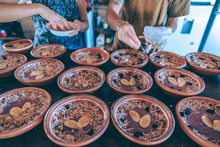 Preparing multiple bowls of fresh fruit and cereal at Soul Medicine in Nayarit, Mexico.
