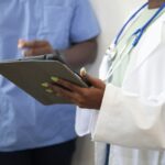 A clinician reviews assessment results with a patient on a tablet