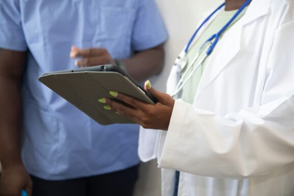 A clinician reviews assessment results with a patient on a tablet